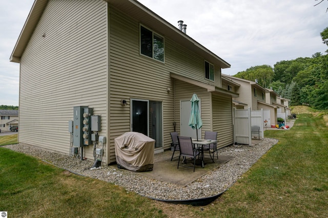 back of house with a patio and a yard