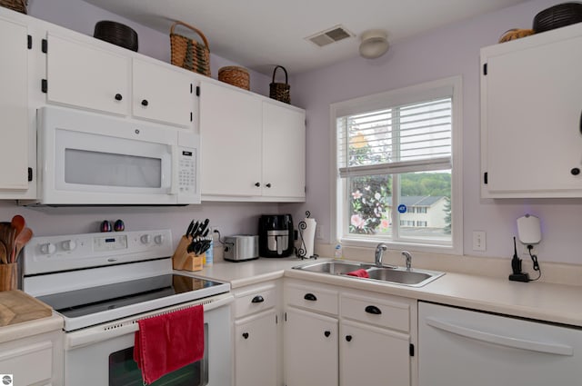 kitchen featuring sink, white appliances, and white cabinets