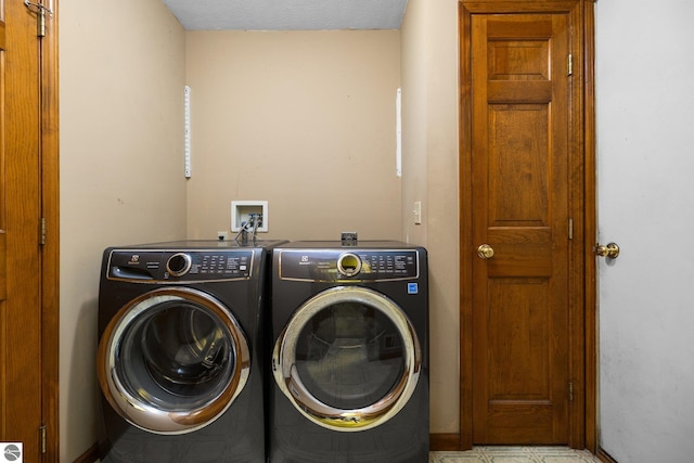 clothes washing area with a textured ceiling and washing machine and dryer