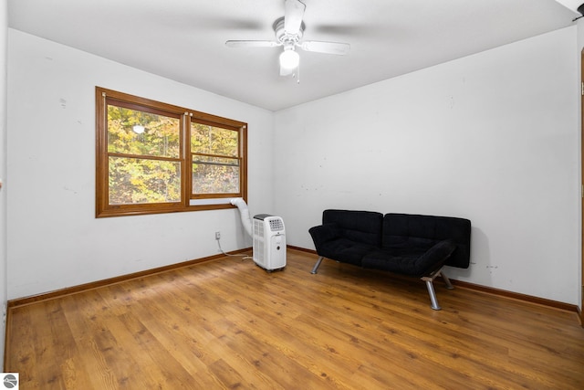 living area featuring wood-type flooring and ceiling fan