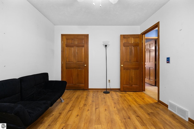 living area featuring a textured ceiling and light wood-type flooring