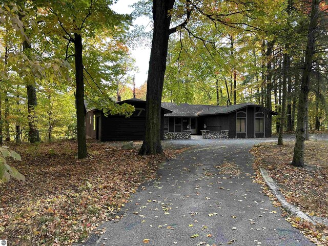 5417 Golfview Rd, Bellaire, MI 49615 - ranch-style house featuring curved driveway and a sunroom