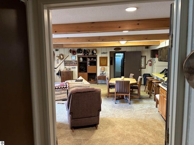 living room with carpet flooring, beam ceiling, and a textured ceiling