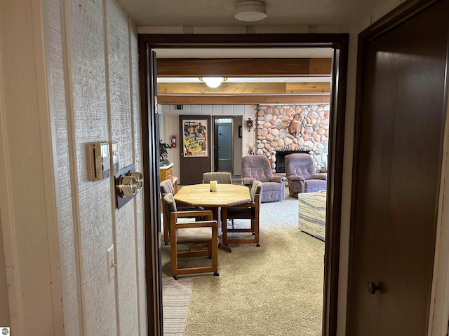 carpeted dining room with a fireplace