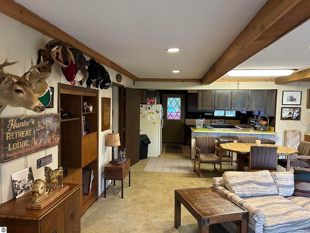 kitchen with beamed ceiling, white fridge, light carpet, and a textured ceiling