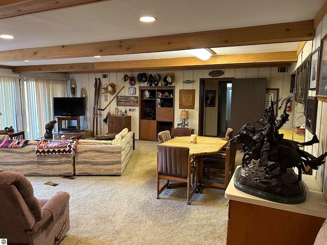 living room with beamed ceiling, a textured ceiling, and carpet floors