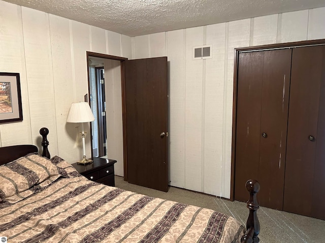 carpeted bedroom featuring a textured ceiling and a closet