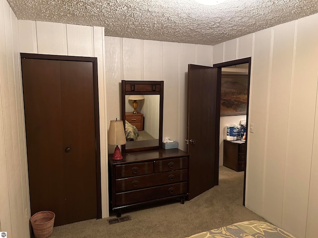 carpeted bedroom featuring a closet and a textured ceiling