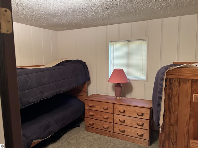 bedroom featuring light colored carpet and a textured ceiling