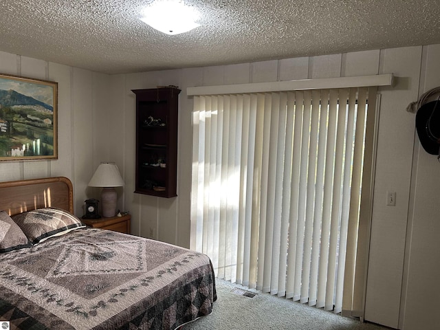 5417 Golfview Rd, Bellaire, MI 49615 - bedroom with visible vents, a textured ceiling, and carpet floors