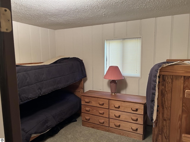 5417 Golfview Rd, Bellaire, MI 49615 - bedroom with a textured ceiling, a decorative wall, and carpet