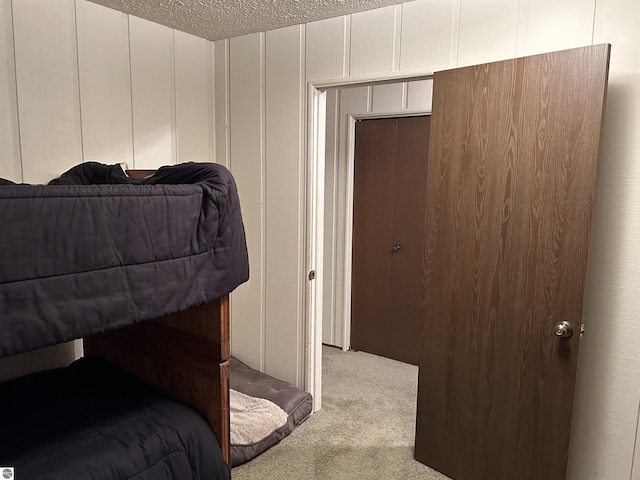 5417 Golfview Rd, Bellaire, MI 49615 - bedroom featuring a decorative wall, light colored carpet, and a textured ceiling