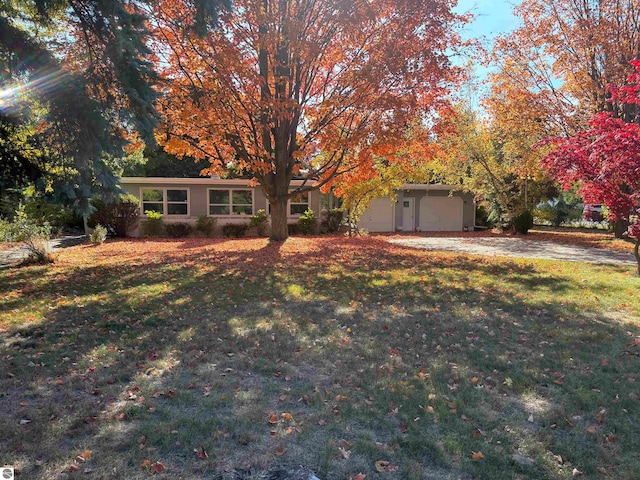 view of property hidden behind natural elements with a front yard and a garage