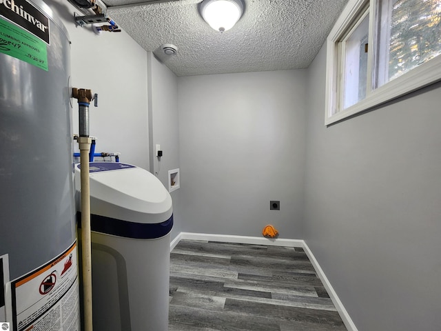 clothes washing area featuring a textured ceiling, water heater, dark wood-type flooring, electric dryer hookup, and washer hookup