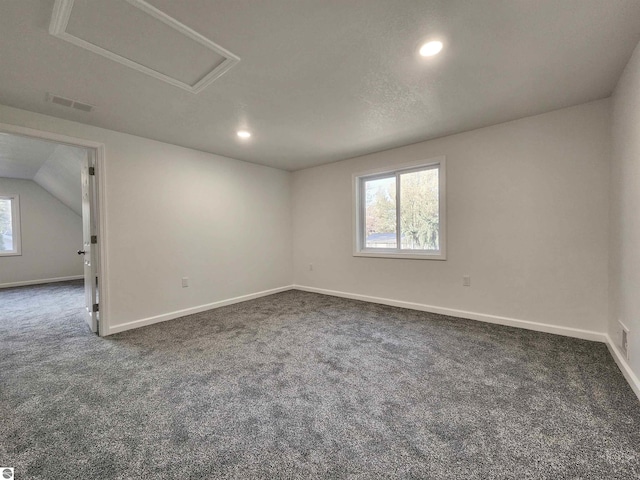 carpeted spare room featuring lofted ceiling