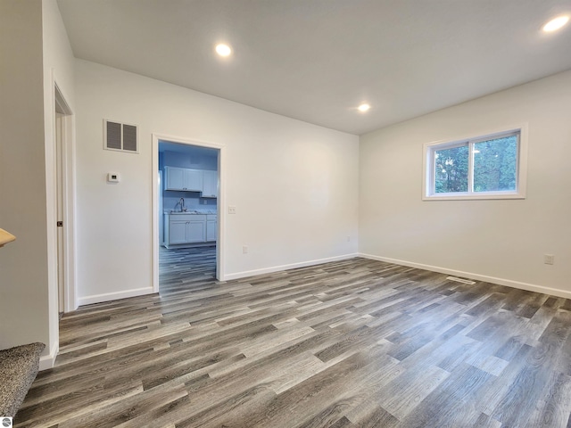 empty room with dark wood-type flooring and sink