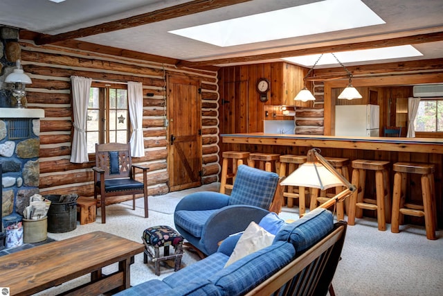 carpeted living room featuring a wall mounted air conditioner, beamed ceiling, plenty of natural light, and rustic walls