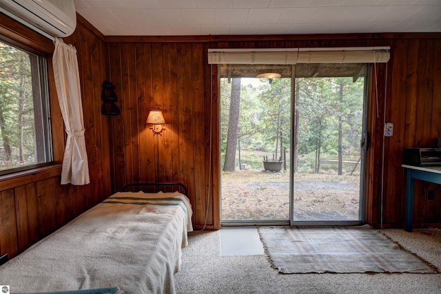 bedroom featuring carpet floors, wooden walls, and a wall unit AC