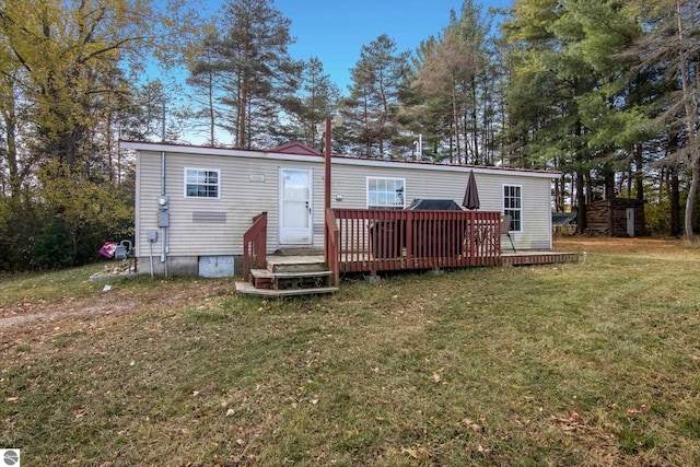 back of house featuring a wooden deck and a yard