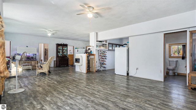 living room featuring dark wood-type flooring and ceiling fan