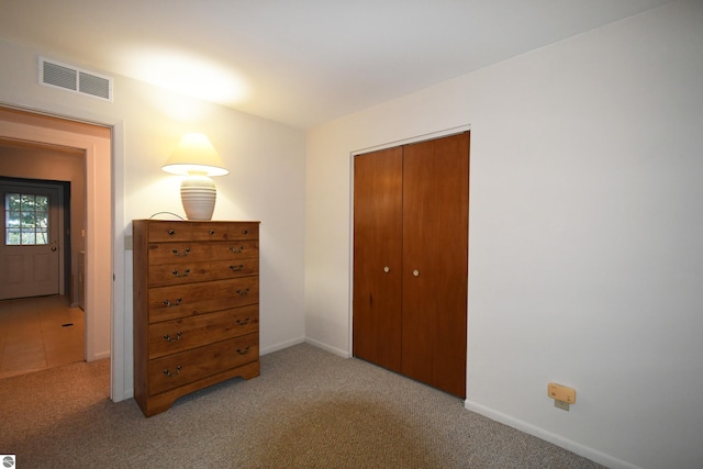 unfurnished bedroom featuring light colored carpet and a closet