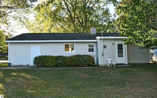 rear view of property featuring a lawn