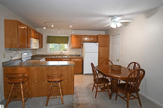 kitchen featuring kitchen peninsula, sink, light tile patterned floors, white appliances, and ceiling fan