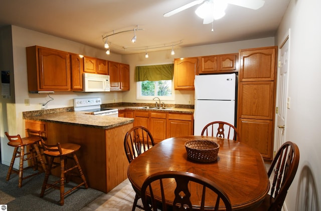 kitchen featuring sink, kitchen peninsula, white appliances, and ceiling fan