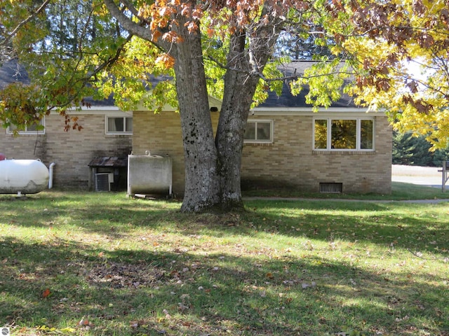 view of side of property featuring a lawn and central AC unit