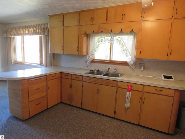 kitchen with kitchen peninsula, tasteful backsplash, and sink