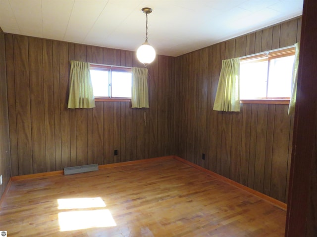 unfurnished room featuring hardwood / wood-style floors and wood walls