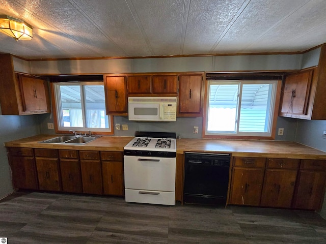 kitchen featuring a healthy amount of sunlight, sink, a textured ceiling, and white appliances