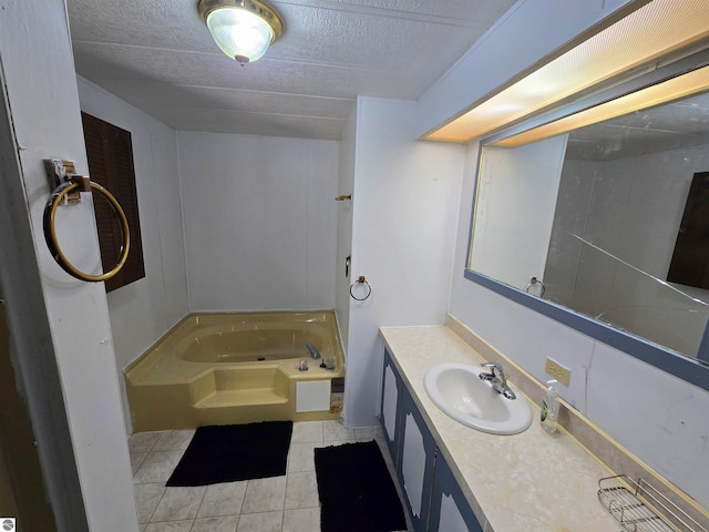 bathroom featuring vanity, a tub to relax in, a textured ceiling, and tile patterned flooring