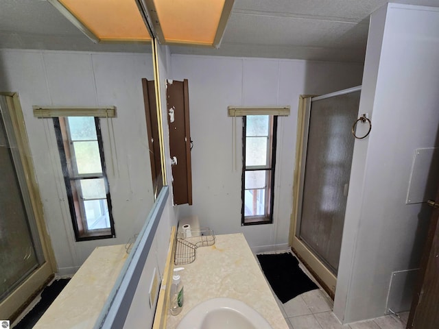 bathroom featuring a shower with door and vanity