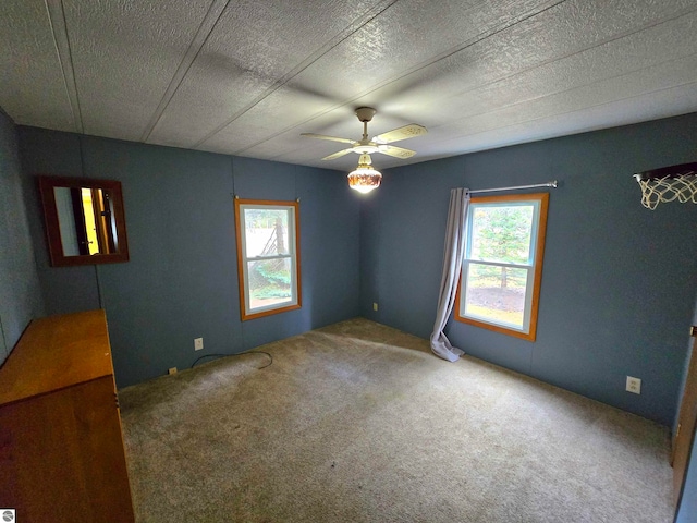 empty room with carpet floors, a textured ceiling, and ceiling fan