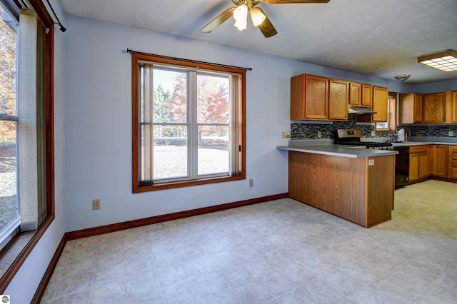 kitchen featuring kitchen peninsula, decorative backsplash, black stove, ceiling fan, and stainless steel range with electric cooktop