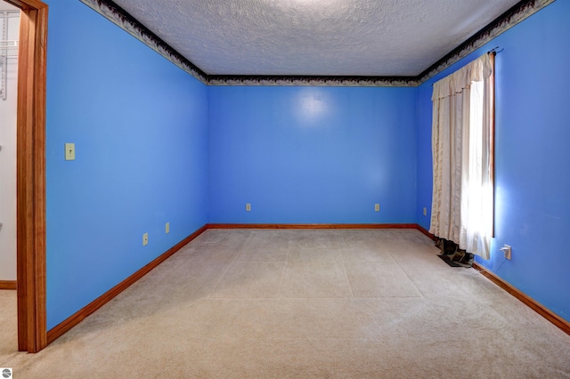 carpeted empty room featuring a textured ceiling