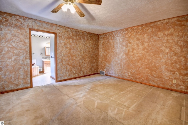 carpeted spare room with ceiling fan and a textured ceiling