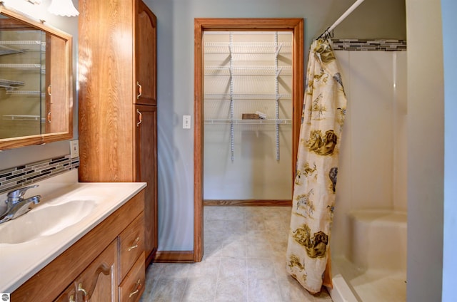 bathroom with a shower with shower curtain, decorative backsplash, tile patterned floors, and vanity