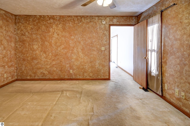 unfurnished room featuring carpet flooring, a textured ceiling, and ceiling fan