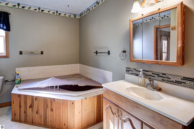 bathroom featuring vanity, toilet, and backsplash