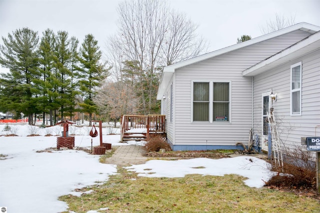 snowy yard featuring a wooden deck