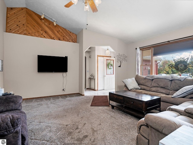 carpeted living room featuring high vaulted ceiling, track lighting, and ceiling fan