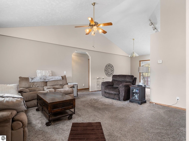 living room with ceiling fan, track lighting, carpet flooring, and vaulted ceiling