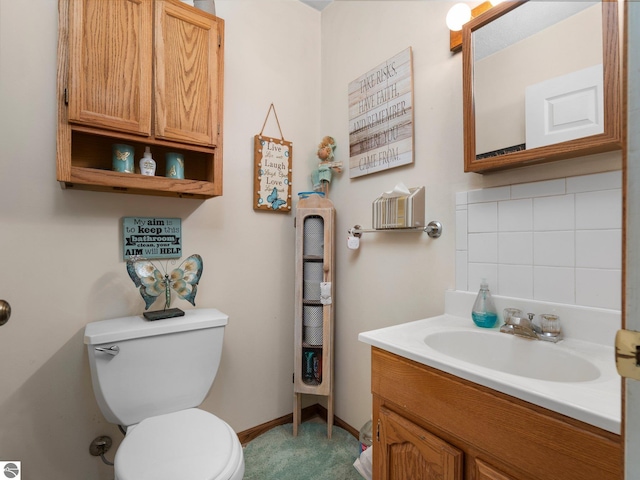 bathroom with vanity, toilet, and decorative backsplash