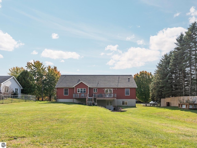 rear view of house with a deck and a yard