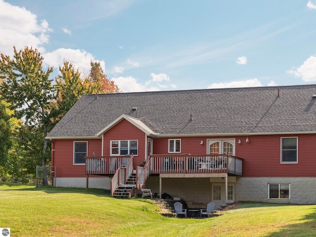 rear view of property featuring a wooden deck and a lawn