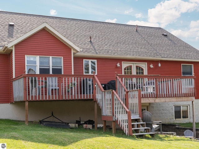 rear view of house with a deck and a lawn