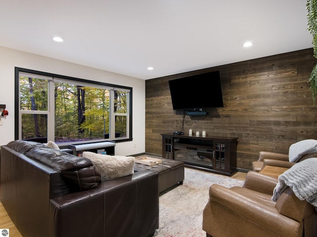 living room with light hardwood / wood-style floors and wooden walls