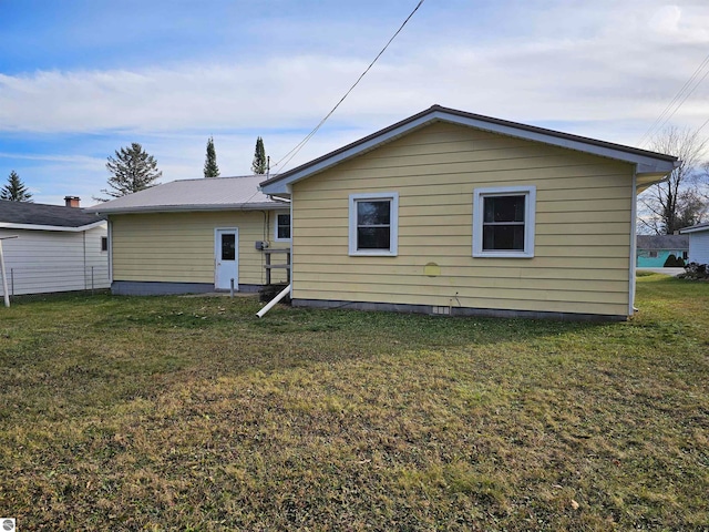 back of property featuring a yard